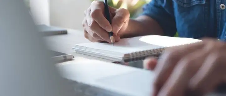 person writing in a notebook