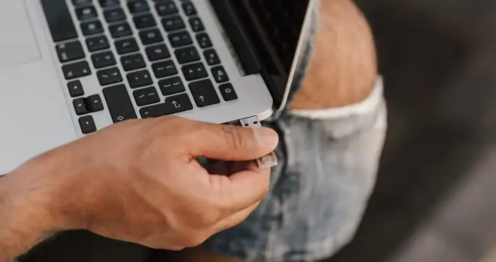 Worker inserting USB stick into port